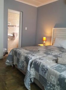 1 dormitorio con 1 cama grande y baño en Umsinsi Cottage en Hluhluwe