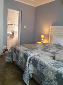 a bedroom with a large bed and a bathroom at Umsinsi Cottage in Hluhluwe +2 photos
