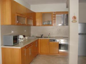 a kitchen with wooden cabinets and stainless steel appliances at A beautiful Beach house Marea Resort in Golem