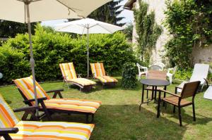 a group of chairs and a table with an umbrella at Altstadtpension Dietz in Kelheim