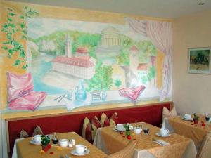 ケールハイムにあるAltstadtpension Dietzの壁画のあるレストランのテーブル2台