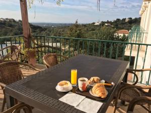 una mesa negra con pan y zumo de naranja en el balcón en Golda Sol, en Loulé