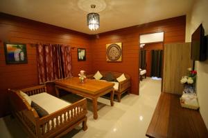 a living room with a table and chairs and a dining room at Sri Siam Resort in Kanchanaburi City