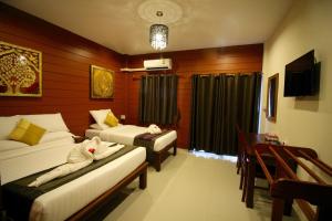 a hotel room with two beds and a window at Sri Siam Resort in Kanchanaburi City +31 photos