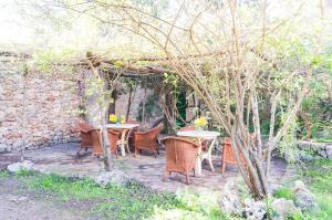 a patio with a table and chairs under a pergola at Sa Casa Rotja in Sineu
