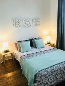 サン・マロにあるChambre d’hotes dans maison conviviale à St Maloのベッドルーム1室(青い枕とランプ2つ付)