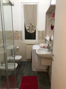 łazienka z umywalką, toaletą i oknem w obiekcie Casa Di TaTa w mieście Trezzo sullʼAdda