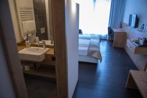 ein Bad mit einem Waschbecken und ein Bett in einem Zimmer in der Unterkunft Hotel zum Hirsch in Wertingen