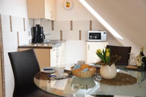 a kitchen with a glass table with a bowl of fruit at Ferienappartement Balik in Bad Staffelstein