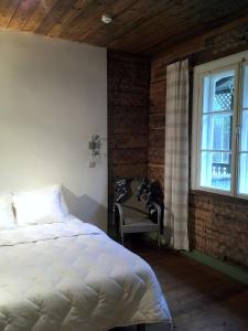 1 dormitorio con cama, ventana y silla en Apartamenti Strand, en Saulkrasti