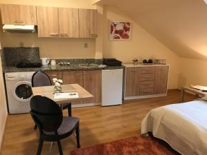 a room with a bed and a kitchen with a table at Willa nad rzeką in Kłodzko