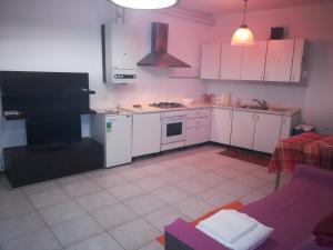 ヴェローナにあるBorgo Roma vic Fieraのキッチン(白い家電製品、紫色のソファ付)