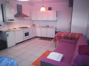 ヴェローナにあるBorgo Roma vic Fieraの紫色のソファ付きのリビングルーム、キッチンが備わります。