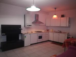 ヴェローナにあるBorgo Roma vic Fieraのキッチン(白いキャビネット、黒い冷蔵庫付)