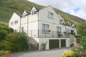 una casa blanca con una colina en el fondo en StoneyGill, en Keswick