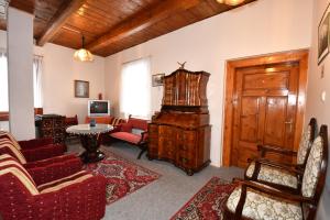 a living room with red furniture and a wooden door at Penzión Villa Breza in Vysoke Tatry - Novy Smokovec