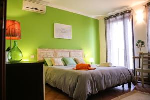 ZollinoにあるLa Muzza - Appartamentoの緑のベッドルーム(オレンジ色の枕付きのベッド付)