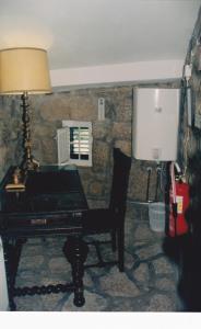 un piano negro en una habitación con lámpara en Casa da Gruta (Cave House), en Monsanto