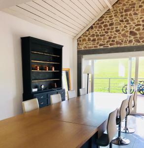 une salle à manger avec une grande table et des chaises en bois dans l'établissement grange enchantée, à Profondeville