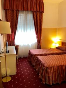 a hotel room with two beds and a window at Hotel Internazionale Gorizia in Gorizia