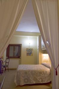 a bedroom with a canopy bed with a table at Casa Aurora in Assisi