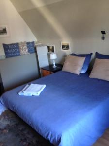 a bedroom with a large blue bed with pillows at Villa Estee in De Haan