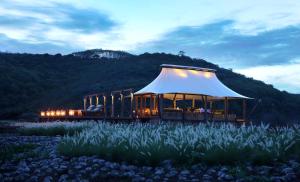 a gazebo with a white roof in a field at Jeeva Beloam Beach Camp in Tanjung Ringgit