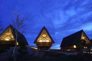 a rendering of two thatched cabins at night at Jeeva Beloam Beach Camp in Tanjung Ringgit