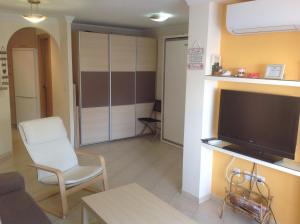 a living room with a tv and a couch and a chair at Apartamento Centro Internacional in Algarrobo-Costa