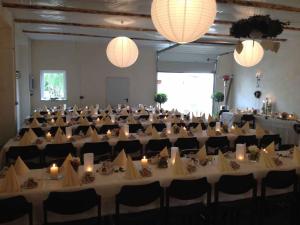 un gran salón de banquetes con mesas y sillas blancas en Wirtshaus "Alte Post", en Zandt