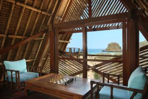 a room with a table and chairs and the ocean at Jeeva Beloam Beach Camp in Tanjung Ringgit
