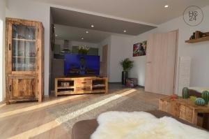 a living room with a flat screen tv on a wooden entertainment center at Zum Fuchsbau in Hettstadt