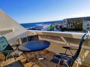 d'une table et de chaises sur un balcon avec vue sur l'océan. dans l'établissement Cap d'Agde Naturist Apartments, au Cap d'Agde