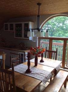 a wooden table with a vase of flowers on it at La Maison Pamaljolie in Ayer's Cliff