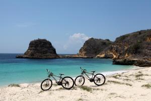 two bikes parked on a beach near the ocean at Jeeva Beloam Beach Camp in Tanjung Ringgit