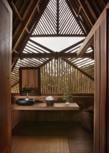 a bathroom with a sink in a wooden building at Jeeva Beloam Beach Camp in Tanjung Ringgit