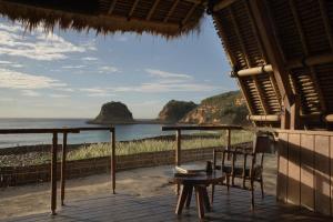 a porch with a view of the ocean at Jeeva Beloam Beach Camp in Tanjung Ringgit