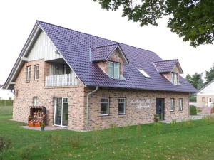 une grande maison en briques avec un toit bleu dans l'établissement Appartements am Schaalsee, à Zarrentin