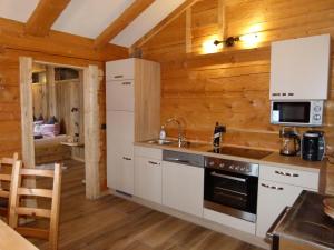 ニーダーンジルにあるSonnberg Apartmentの白い家電製品と木製の壁が備わるキッチン