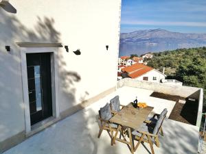 a table and chairs on a balcony with a view at Apartmani Marijana in Postira