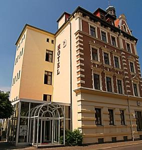 een hoog gebouw met een hek ervoor bij Hotel Merseburger Hof in Leipzig
