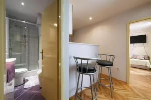 a bathroom with two bar stools and a bedroom at TOP location & WALK SCORE 93 with washing machine in Split