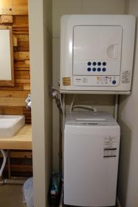 un forno a microonde in cima a un frigorifero in una cucina di Tomarotto Hostel a Takayama