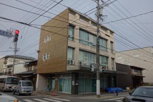 un edificio in una strada cittadina con un semaforo rosso di Tomarotto Hostel a Takayama
