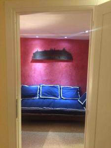 オルヴィエートにあるOrvieto in Terrazzaの赤い壁の部屋の青いソファ