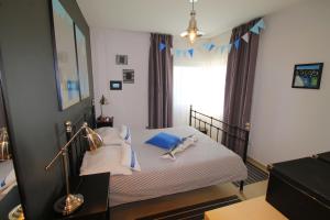 1 dormitorio con 1 cama con sábanas blancas y almohadas azules en Apartments Marer, en Trogir