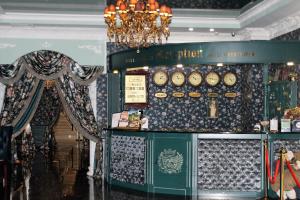 una tienda con relojes en la pared y una lámpara de araña en Green House Hotel Tyumen en Tyumen
