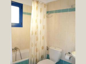 a bathroom with a toilet and a shower curtain at Kionia Apartments in Kerames