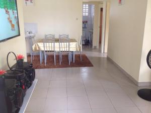 una sala da pranzo con tavolo e sedie su un pavimento piastrellato di Huize Jelano a Paramaribo