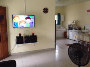 un soggiorno con una TV a schermo piatto su una parete di Huize Jelano a Paramaribo